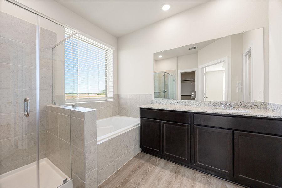The primary bath features clean, modern finishes with a double-sink vanity, soaking tub, and separate shower. Soft tones and sleek lines create a relaxing, spa-inspired atmosphere. The primary bath features clean, modern finishes with a double-sink vanity, soaking tub, and separate shower. Soft tones and sleek lines create a relaxing, spa-inspired atmosphere.