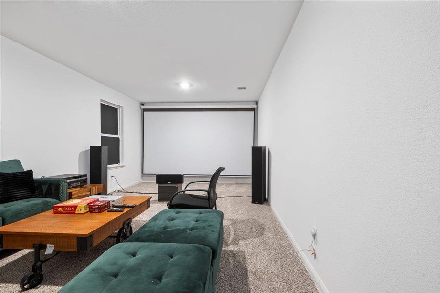 Cinema room with carpet floors and baseboards
