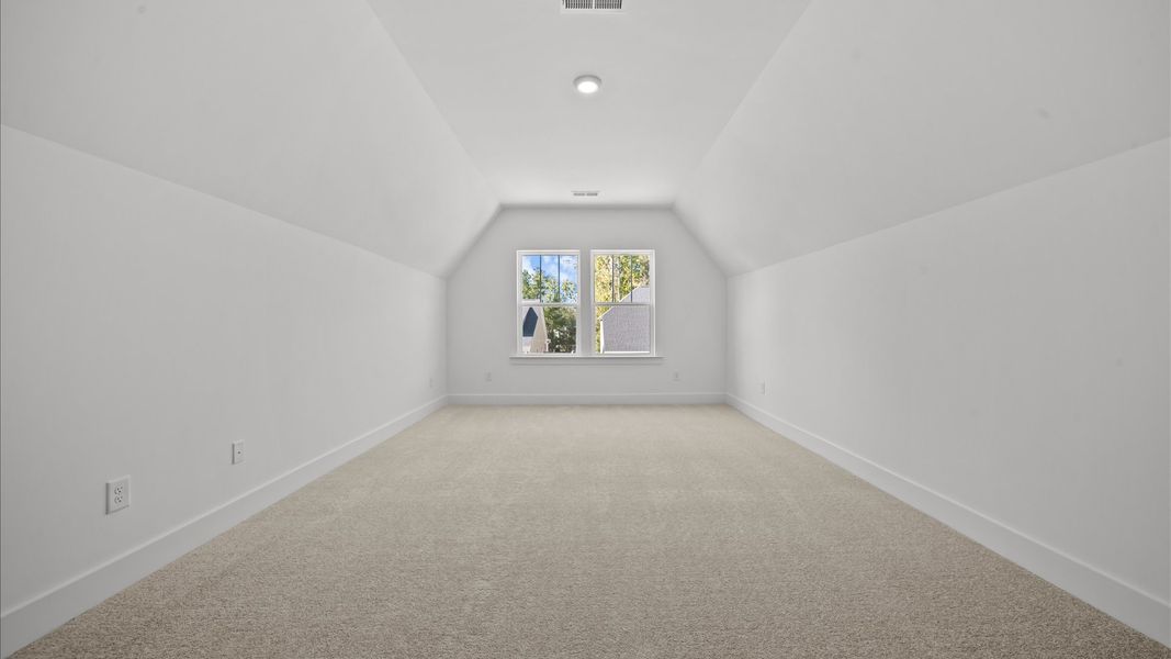 Elegant, carpeted bonus room that adds a superior layer of flexibility to the home’s design