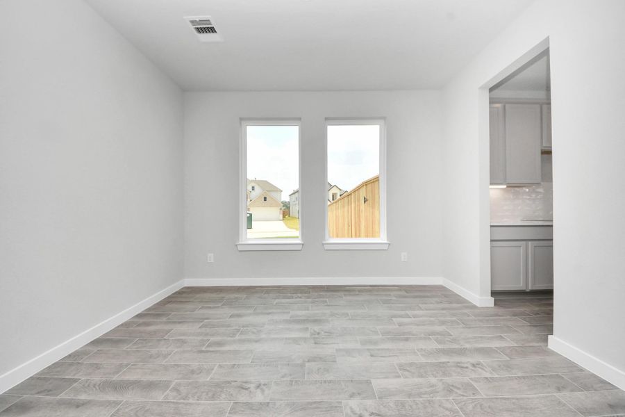Make memories gathered around the table with your family and friends! This spacious dining room features elegant flooring, custom paint, and adjacent to family room and kitchen for open concept feel. Sample photo of completed home with similar floor plan. Actual colors and selections may vary.