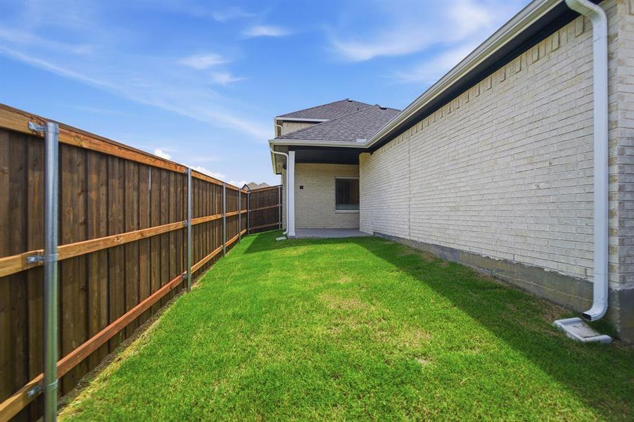 Lush green lawn with a newly installed wooden privacy fence