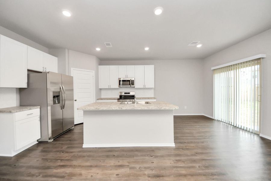 White kitchen connects to the dining area with sliding patio doors to your backyard. White kitchen connects to the dining area with sliding patio doors to your backyard.