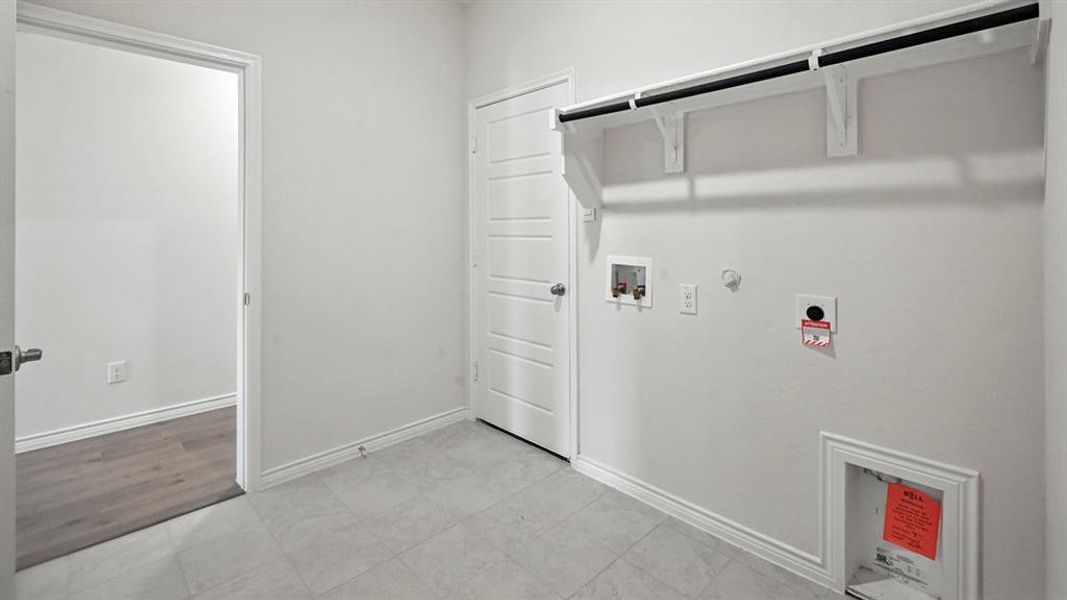 Utility room featuring light gray tile flooring and white baseboards