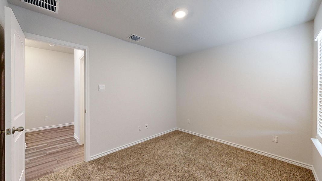 Spare room with light carpet and baseboards Spare room with light carpet and baseboards