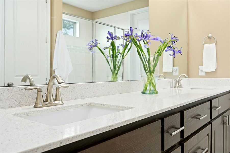 Quartz countertops in primary ensuite with dual vanity space.