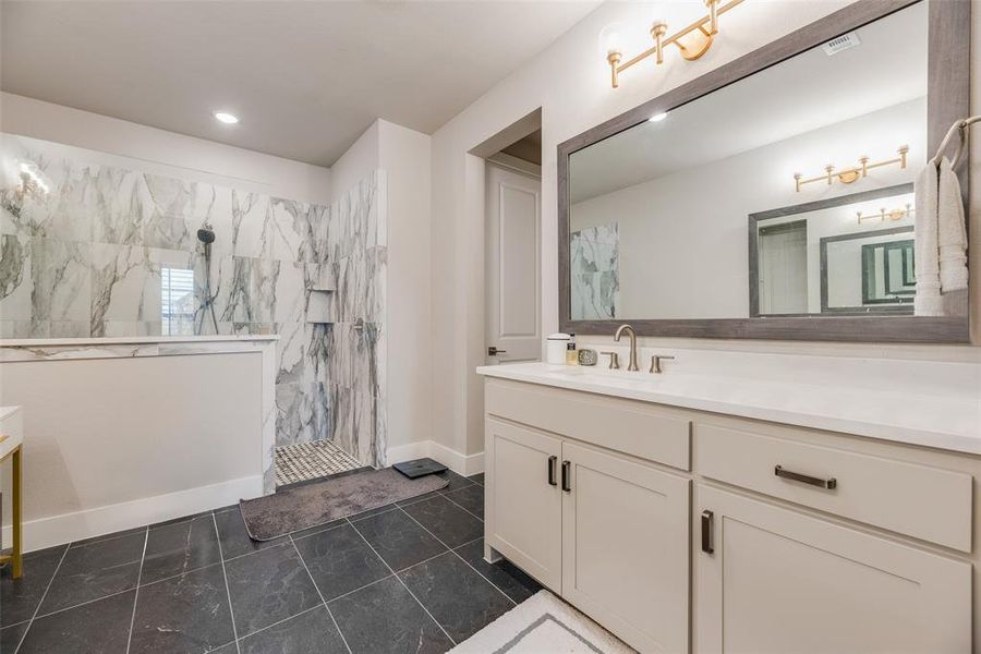 Walk-in shower with marble-look tile surround and built-in niche