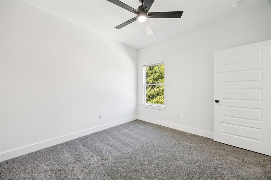 Spare room with carpet and a ceiling fan