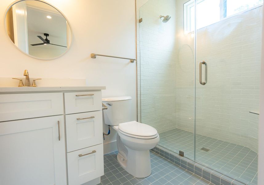 A well-appointed bathroom offers sleek vanity storage, a modern toilet, and a spacious glass-enclosed shower. A well-appointed bathroom offers sleek vanity storage, a modern toilet, and a spacious glass-enclosed shower.