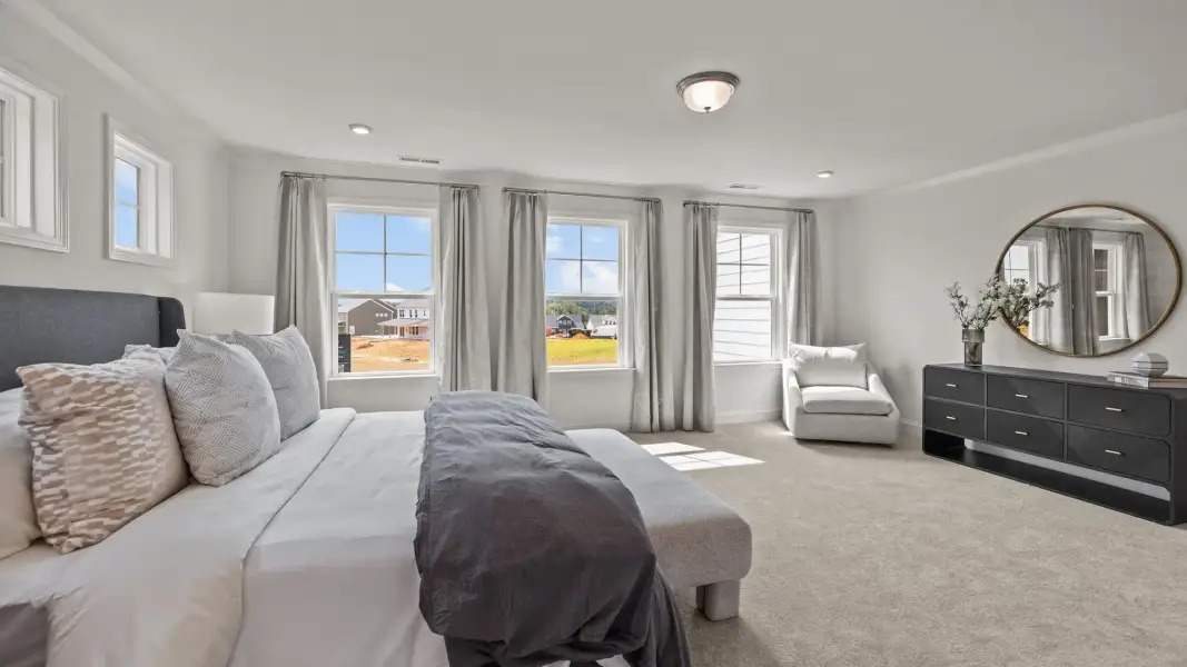 Luxurious primary bedroom retreat with plentiful windows in the Townsend Design by DRB Homes in Lakeside Glen, York, SC Luxurious primary bedroom retreat with plentiful windows in the Townsend Design by DRB Homes in Lakeside Glen, York, SC