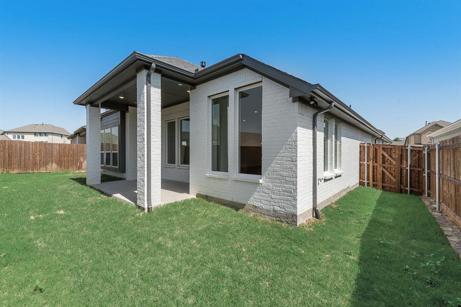 View of side of property featuring brick siding, a patio, a fenced backyard, and a gate View of side of property featuring brick siding, a patio, a fenced backyard, and a gate