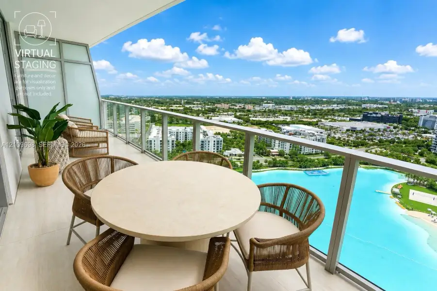Covered balcony featuring large-format tile flooring and a sleek metal railing with glass panels, overlooking a prominent turquoise lagoon and expansive horizon