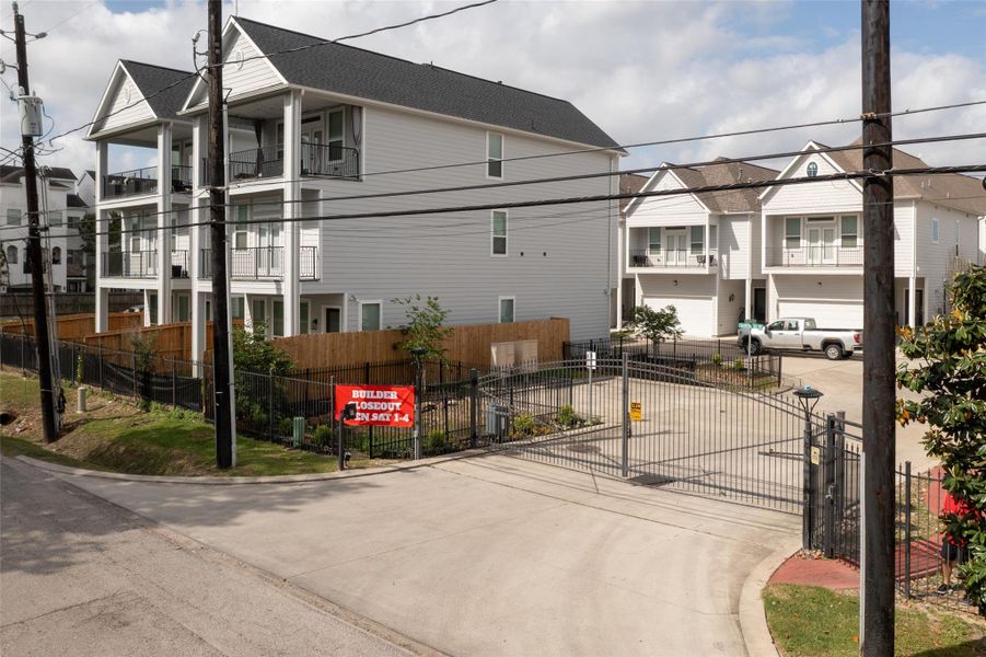 Modern multi-story homes with balconies, set within a gated community.