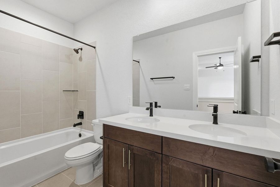 Full bathroom with double vanity,  shower combination, and light tile patterned floors