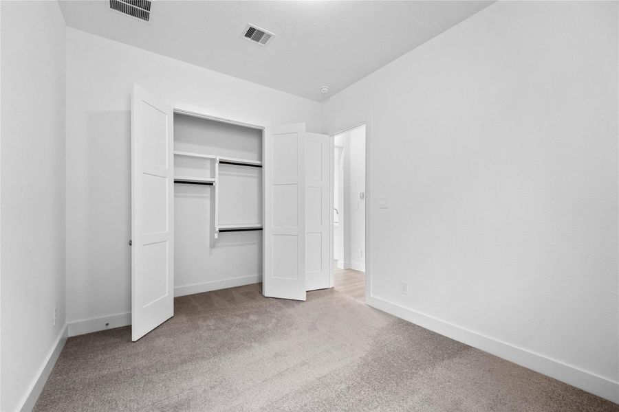 The secondary closet with built in shelving and multiple rows to hang clothing.