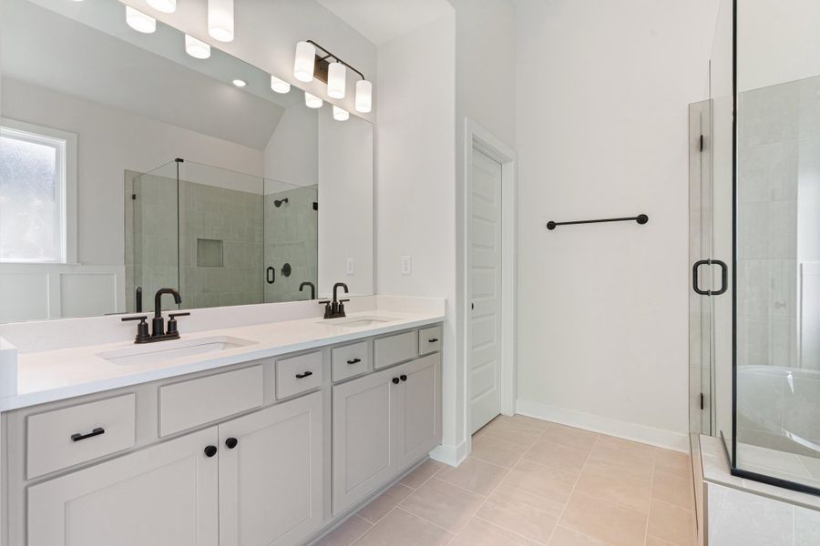 Dual vanity with undermount sinks, stone countertops, and matte black fixtures