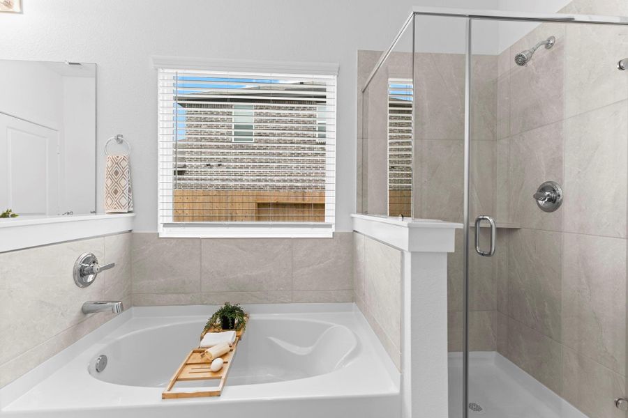 The primary bathroom also includes a deep soaking tub and separate glass-enclosed shower with tile surround—perfect for relaxing after a long day. **Image Representative of Plan Only and May Vary as Built**.