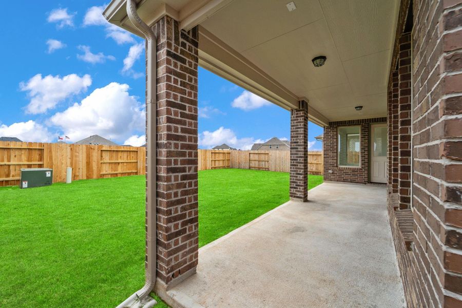 The covered patio is generously sized, providing ample space for various outdoor activities.