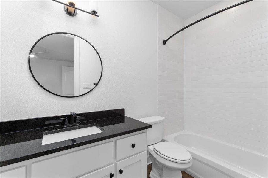 Full bathroom with vanity, toilet, and washtub / shower combination Full bathroom with vanity, toilet, and washtub / shower combination