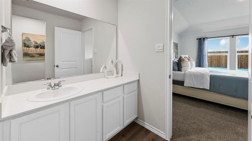 Bathroom with ensuite bath, vanity, vaulted ceiling, and dark carpet Bathroom with ensuite bath, vanity, vaulted ceiling, and dark carpet