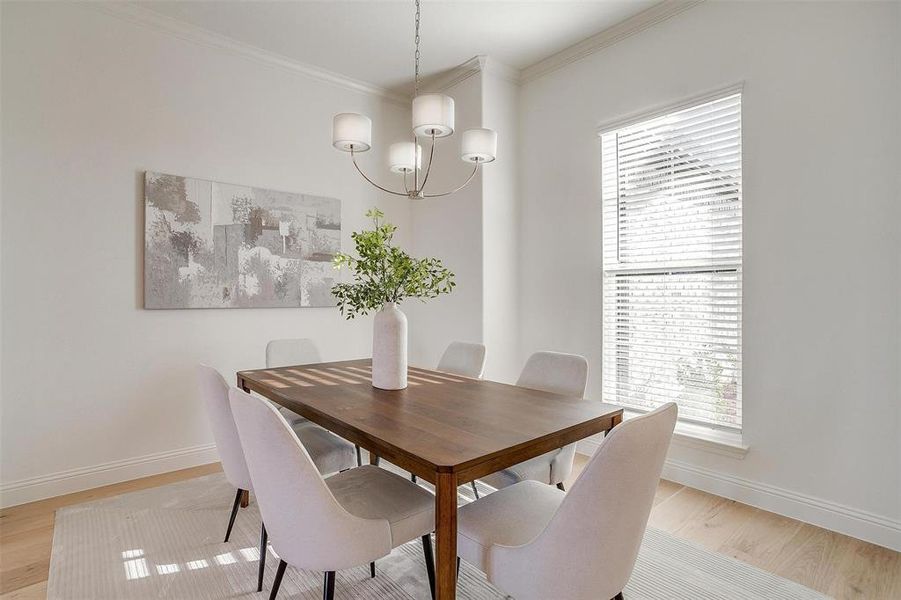 Dining room with light hardwood / wood-style floors, ornamental molding, and a wealth of natural light