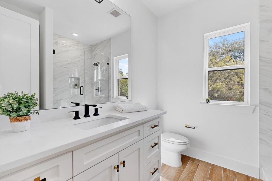 Bathroom with vanity, wood finished floors, and a marble finish shower