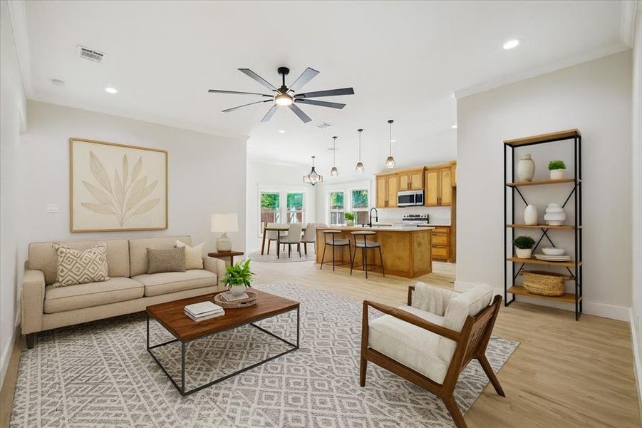 Living area featuring light wood finished floors, recessed lighting, a ceiling fan, and a chandelier