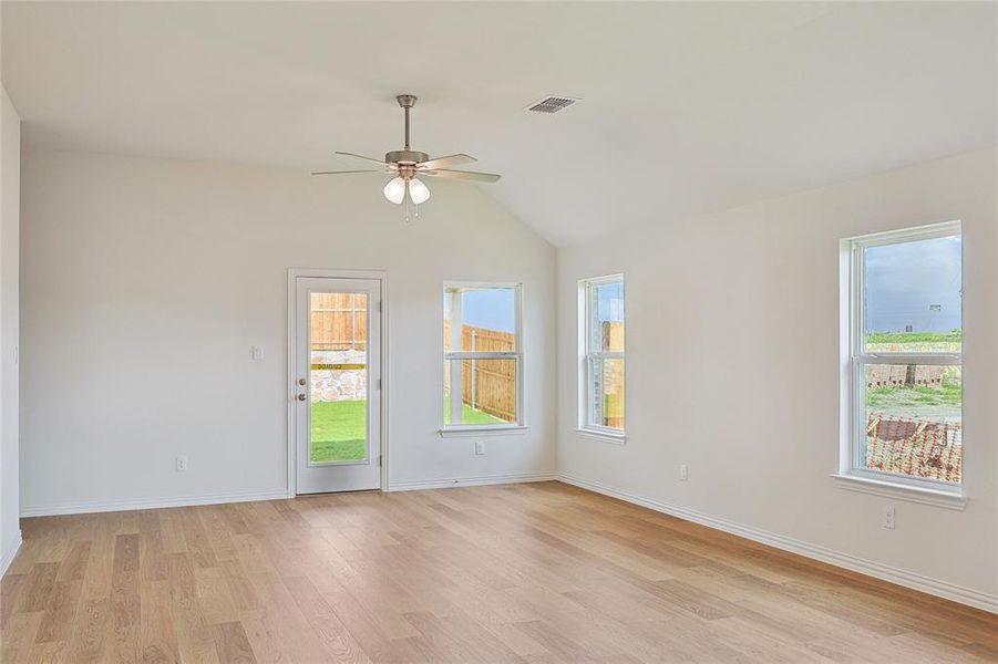 Spare room with ceiling fan, vaulted ceiling, and light hardwood / wood-style flooring