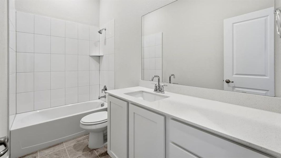 Bathroom with shower / tub combination, vanity, and light tile patterned floors