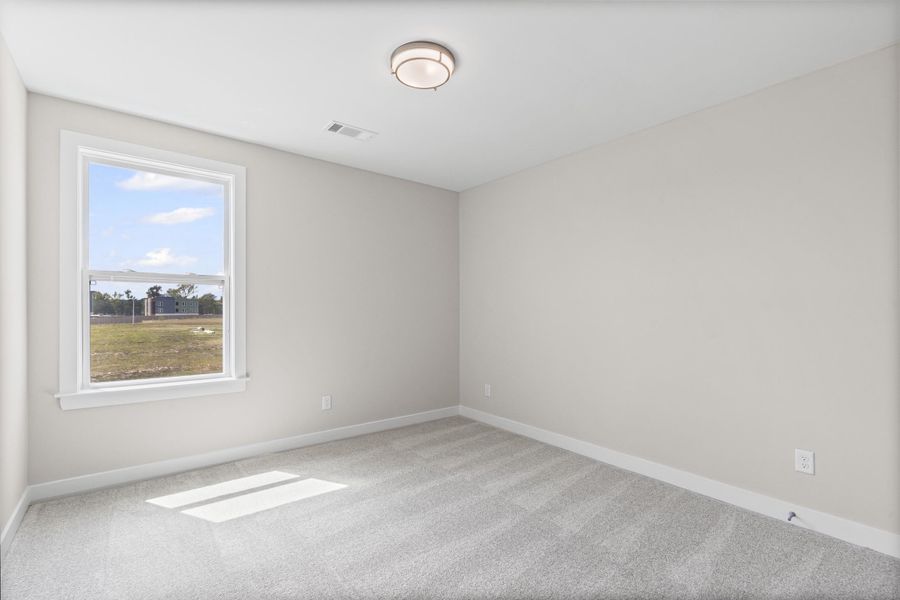 Carpeted empty room featuring baseboards