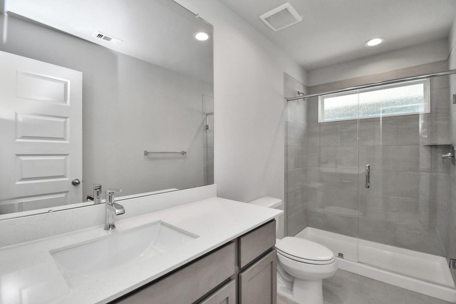 Secondary bath features tile flooring, bath/shower combo with tile surround, light stained wood cabinets, beautiful light countertop. Sample photo of completed home with similar floor plan. Actual colors and selections may vary. Secondary bath features tile flooring, bath/shower combo with tile surround, light stained wood cabinets, beautiful light countertop. Sample photo of completed home with similar floor plan. Actual colors and selections may vary.