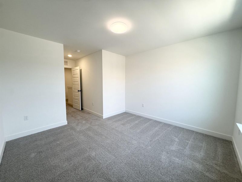 Carpeted empty room with baseboards and recessed lighting