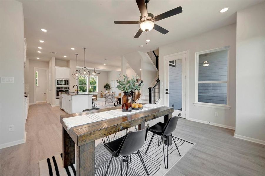 Open-concept dining area featuring wood-finish flooring, recessed lighting, and a ceiling fan