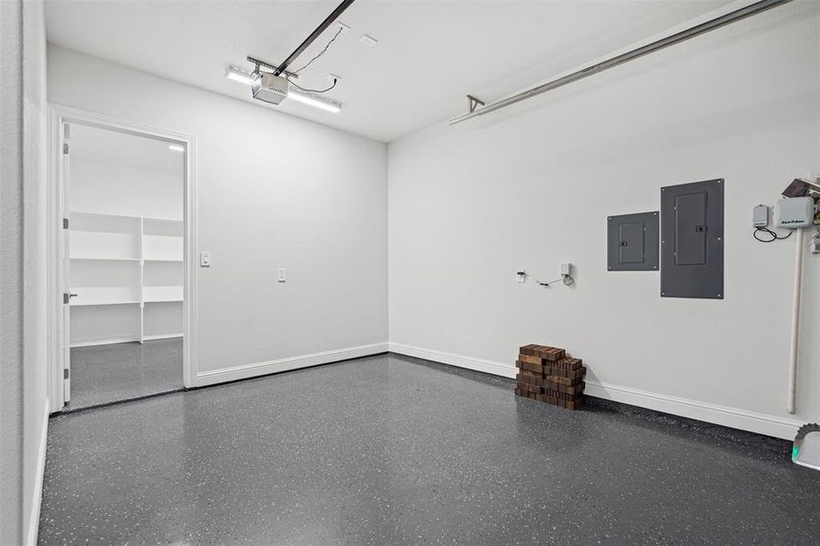 One-Car Garage featuring electric panel and entrance to storage room One-Car Garage featuring electric panel and entrance to storage room