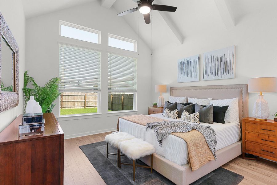 Soaring vaulted ceilings and wide-plank wood floors elevate this tranquil main-level bedroom.