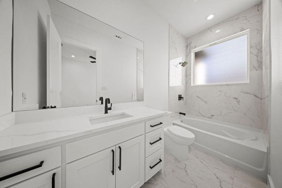 Full bathroom with vanity, a combined bath / shower with marble appearance, light marble finish flooring, and recessed lighting
