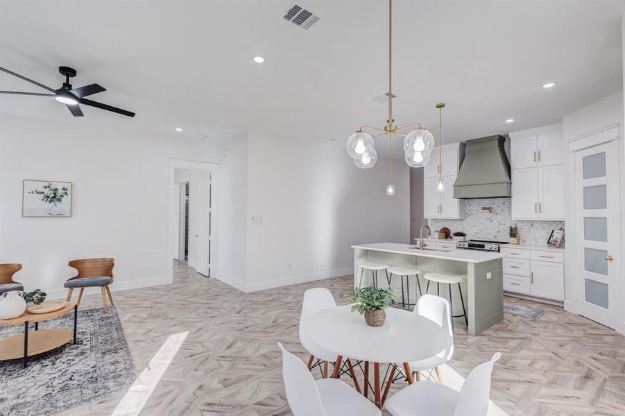 Dining room featuring ceiling fan, sink, and light parquet flooring