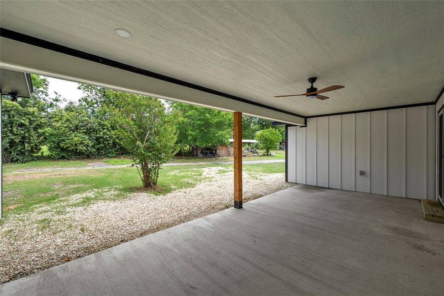 Covered concrete patio with a wood-finish ceiling fan, recessed lighting, and a wood post Covered concrete patio with a wood-finish ceiling fan, recessed lighting, and a wood post