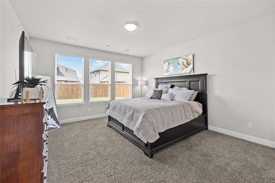 This expansive primary bedroom serves as a true private sanctuary, boasting a generous layout with more than enough space to create a dedicated retreat. You will absolutely love the cozy area nestled by the large windows—perfect for a private reading nook, an intimate seating arrangement, or a peaceful spot to unwind while enjoying the bright, natural light.