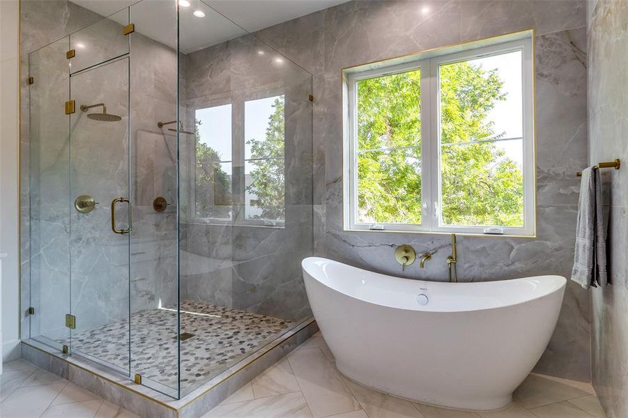 Bathroom featuring a wealth of natural light, tile walls, and tile patterned floors