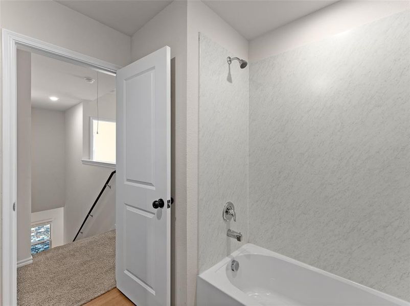 Bathroom featuring wood-type flooring and shower / washtub combination