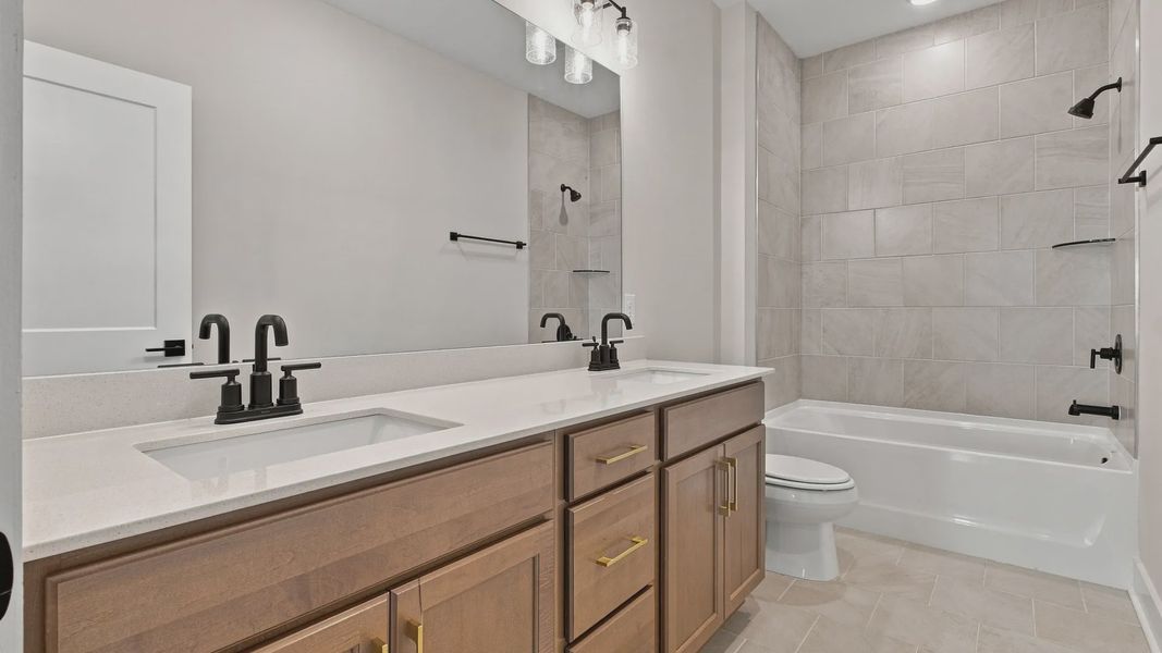 Larger upstairs bathroom featuring dual sinks as well as a bathtub.