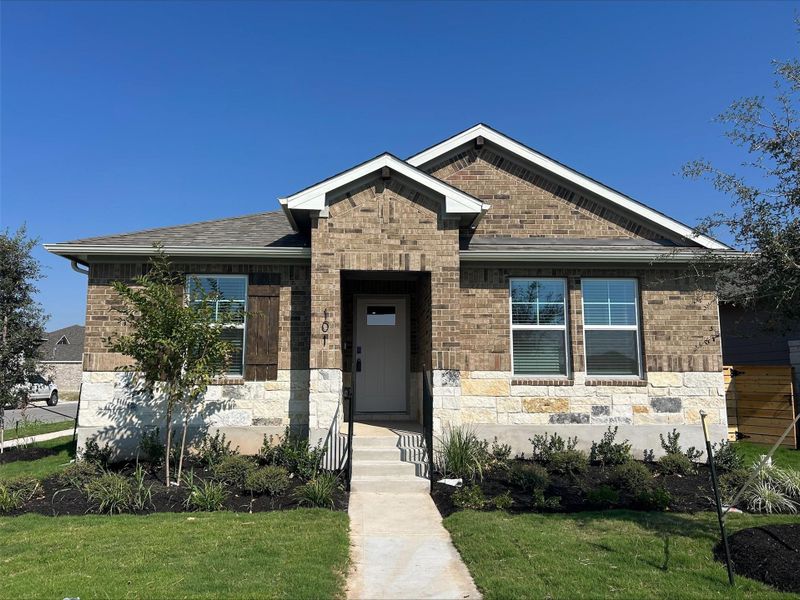 View of front facade featuring a front lawn, brick siding, stone siding, and roof with shingles View of front facade featuring a front lawn, brick siding, stone siding, and roof with shingles