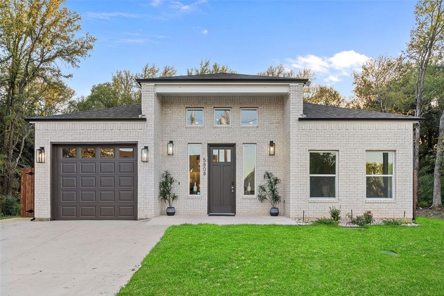 View of front facade with a front yard and a garage