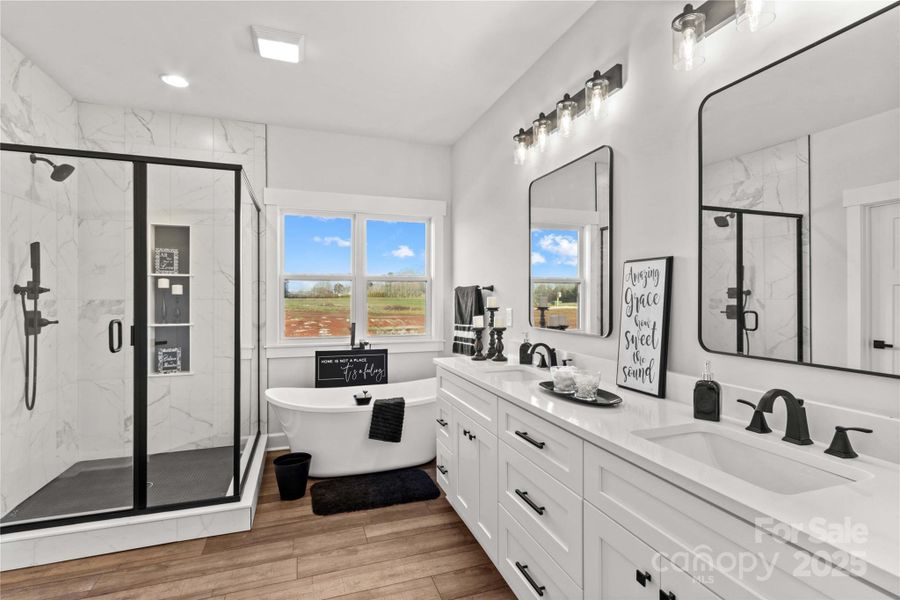 THREE FULL BATHS IN HOME. This is the 1st primary Bedroom Bath suite. Dual quartz vanities, walk in glass & tiled shower & Roman soaking Tub. (Lots of cabinets& updated fixtures.)