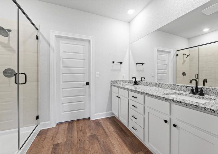 <p>Master bathroom featuring a luxurious dual sink vanity with a beautifully tiled walk-in shower. </p>