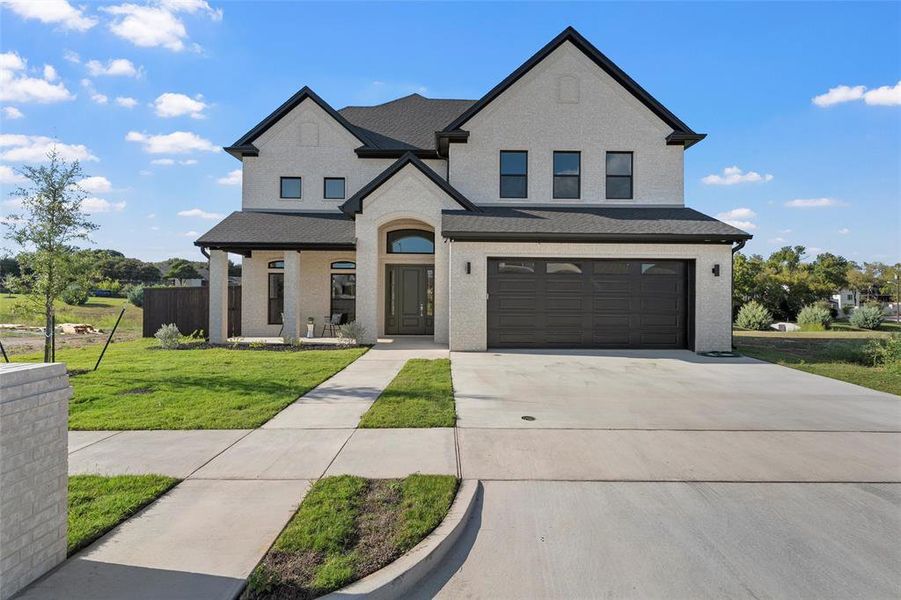 View of front of house with driveway, brick siding, an attached garage, a porch, and roof with shingles View of front of house with driveway, brick siding, an attached garage, a porch, and roof with shingles