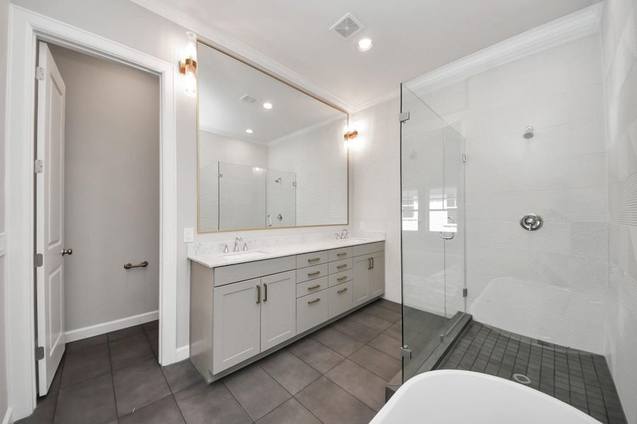 Spa-inspired primary bath with dual sinks, Carrara countertops, and designer details. Spa-inspired primary bath with dual sinks, Carrara countertops, and designer details.