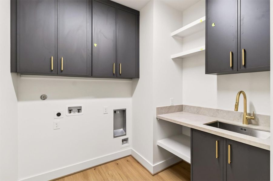 A well-appointed and functional laundry room designed for everyday convenience, featuring ample countertop space for folding, custom cabinetry for organized storage, and a clean, modern aesthetic. A well-appointed and functional laundry room designed for everyday convenience, featuring ample countertop space for folding, custom cabinetry for organized storage, and a clean, modern aesthetic.