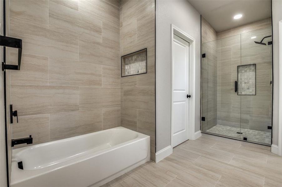 Full bath featuring a shower stall and a bathtub Full bath featuring a shower stall and a bathtub