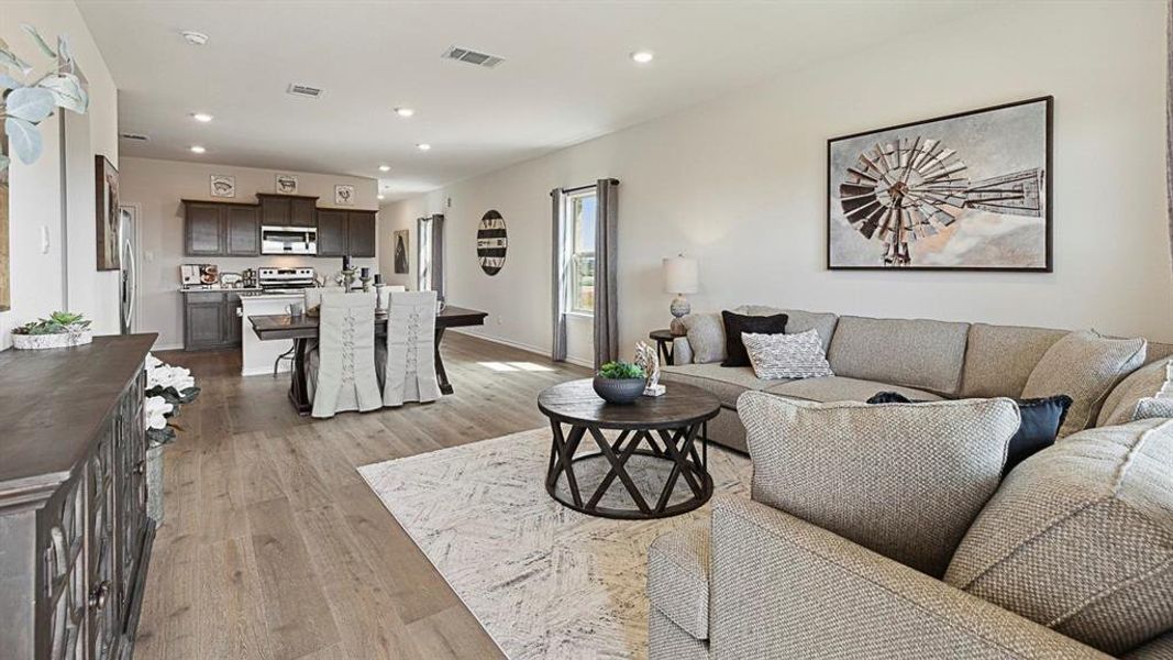 The property features an open-concept living area with hardwood flooring, recessed lighting, and large windows providing natural light